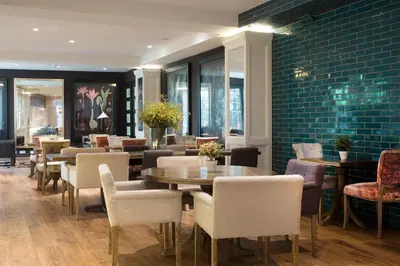 a restaurant with tables and chairs and a brick wall at Ofelias Hotel 4Sup in Barcelona