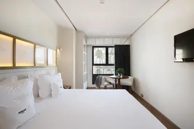 a bedroom with a large white bed and a table at Ofelias Hotel 4Sup in Barcelona