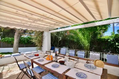 a dining room with a table and chairs on a patio at Villa Bianca in Sitges