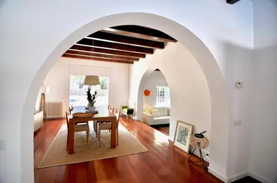 an archway in a living room with a table at Villa Bianca in Sitges
