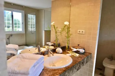 a bathroom with a sink and a toilet and a mirror at Villa Bianca in Sitges