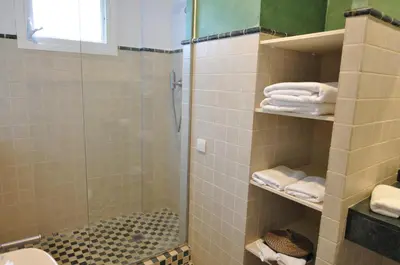 a bathroom with a shower and a toilet and towels at Villa Bianca in Sitges