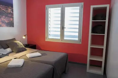 a red room with two beds and a window at HelloBCN Youth Hostel Barcelona in Barcelona