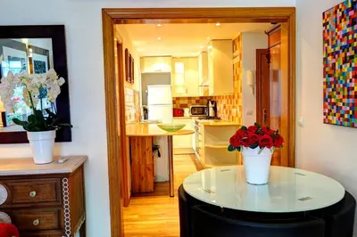 a kitchen with a table with flowers on it at Olivia Apartment by Hello Homes Sitges in Sitges