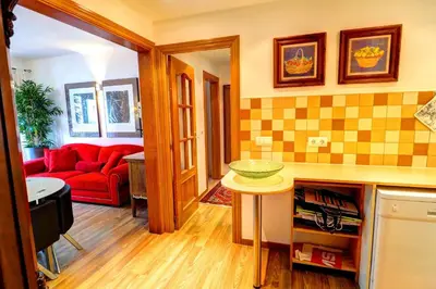 a living room with a red couch and a table at Olivia Apartment by Hello Homes Sitges in Sitges