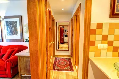 a hallway with a red couch and a red rug at Olivia Apartment by Hello Homes Sitges in Sitges