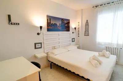 a bedroom with a bed with white sheets and towels at Lucy Apartment by Hello Homes Sitges in Sitges