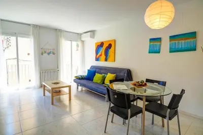 a living room with a blue couch and a table at Lucy Apartment by Hello Homes Sitges in Sitges