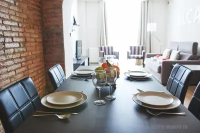 a dining room table with plates and glasses on it at Alcam Alio 1 in Barcelona