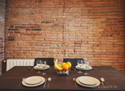 a table with a bowl of fruit and a brick wall at Alcam Alio 1 in Barcelona