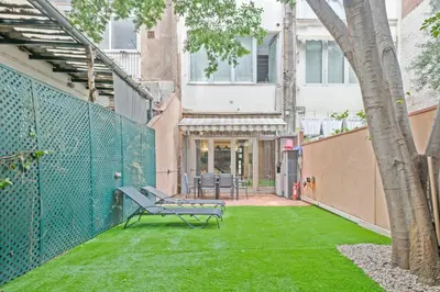 a bench sitting on the grass in a yard at Alcam Loft Grassot in Barcelona