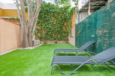 a patio with two lawn chairs and a fence at Alcam Loft Grassot in Barcelona