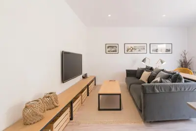 a living room with a couch and a flat screen tv at Petit Luxe Dúplex in Terrassa