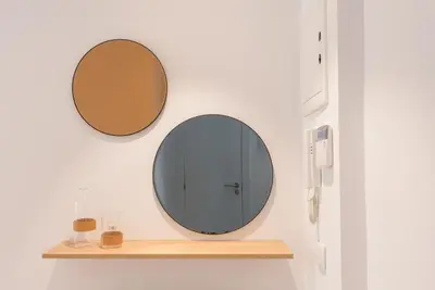 a mirror on a wall next to a shelf at Petit Luxe Dúplex in Terrassa