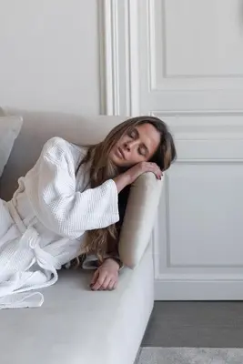 a woman is laying on a white couch at El Palauet Modernist Suites Barcelona in Barcelona