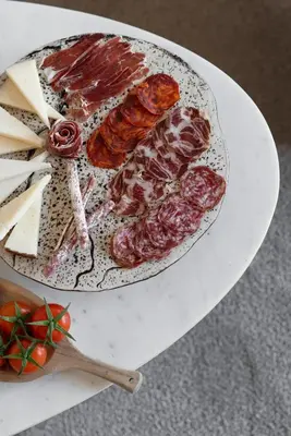 a plate of meat and cheese on a table at El Palauet Modernist Suites Barcelona in Barcelona