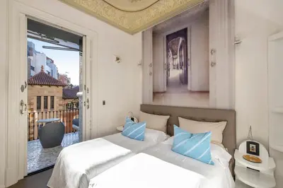 a bedroom with a bed and a large window at El Palauet Modernist Suites Barcelona in Barcelona