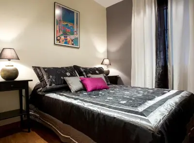 a bedroom with a large bed with a pink pillow at Avinguda Gaudi Apartment in Barcelona
