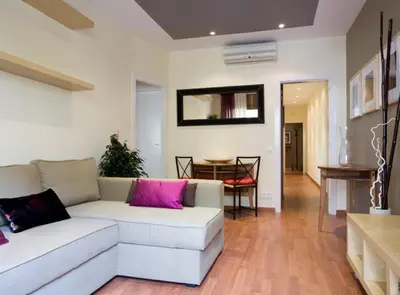 a living room with a white couch and pink pillows at Avinguda Gaudi Apartment in Barcelona