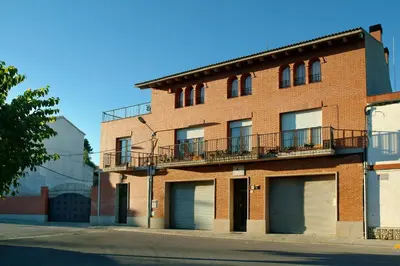 a red brick building with two garage doors on a street at Agroturisme Cal Jeroni in Avinyonet