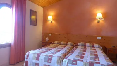 a bedroom with a bed and two lights on the wall at Agroturisme Cal Jeroni in Avinyonet