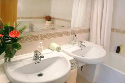 a bathroom with two sinks and a mirror at Agroturisme Cal Jeroni in Avinyonet