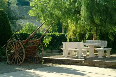 a picnic table and a wooden cart in a park at Agroturisme Cal Jeroni in Avinyonet