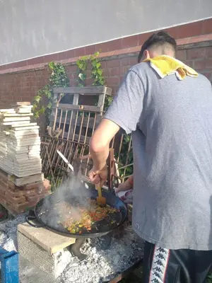 a man cooking food on top of a grill at Agroturisme Cal Jeroni in Avinyonet