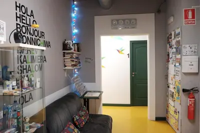 a room with a black leather couch and a door at Sleep Green - Certified Eco Youth Hostel in Barcelona