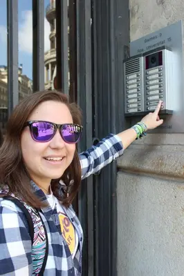a young woman wearing purple glasses standing next to a wall at Sleep Green - Certified Eco Youth Hostel in Barcelona