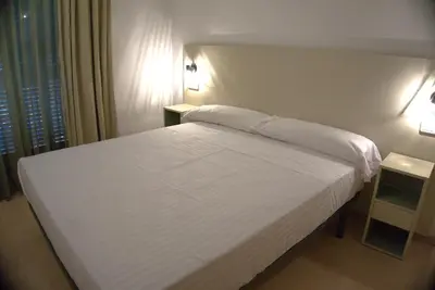 a bedroom with a white bed with two night stands at Apartaments Sant Jordi Fontanella in Barcelona
