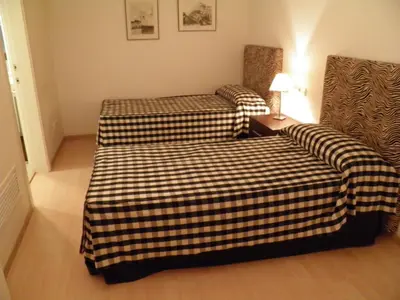 a room with two beds and a table with a lamp at Apartaments Sant Jordi Fontanella in Barcelona