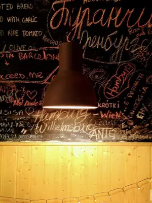 a pendant light hanging on a wall with writing on it at Buba House - Women Only Hostel in Barcelona