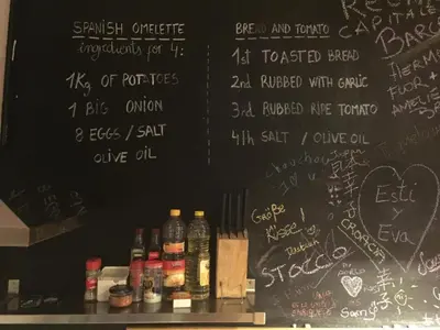 a black wall with writing on it with bottles on a shelf at Buba House - Women Only Hostel in Barcelona