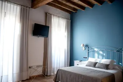 a blue bedroom with a bed and a tv at Sa Voga Hotel & Spa in Arenys de Mar