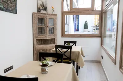a dining room with two tables and two windows at Sa Voga Hotel & Spa in Arenys de Mar