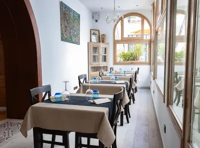 a row of tables in a restaurant with a window at Sa Voga Hotel & Spa in Arenys de Mar