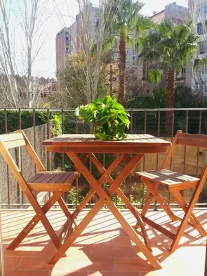 a wooden table with two chairs and a potted plant at Lovely double apartment - Sagrada Familia - Air conditioning in Barcelona