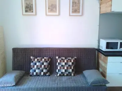 a couch in a room with two pillows and a microwave at Lovely double apartment - Sagrada Familia - Air conditioning in Barcelona