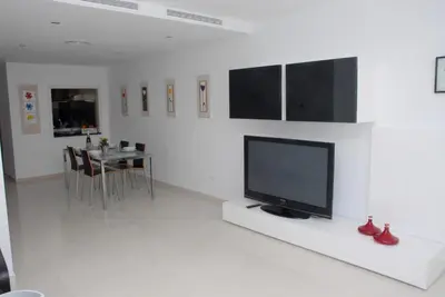 a living room with a television on a white wall at Apartamento Montroig 3 Ático in Sitges