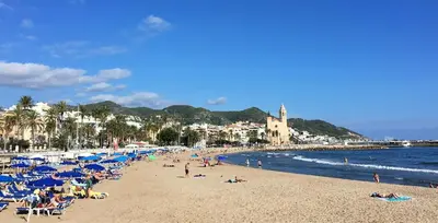 a beach with a lot of people laying on the sand at Apartamento Montroig 3 Ático in Sitges