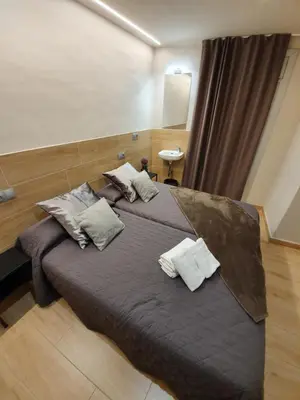 a bedroom with a large bed with pillows on it at Pensión San Ramón in Barcelona