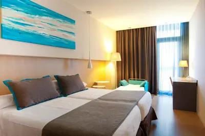 a hotel room with a large bed and a large painting at Atenea Port Barcelona Mataró in Mataró