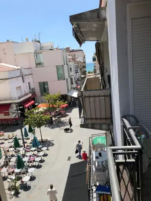a balcony of a building with people sitting on chairs at Apartamento Montroig 1 in Sitges