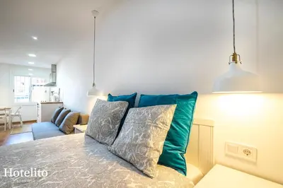 a living room with a bed with two pillows at Hotelito Boutique Mercat in Hospitalet de Llobregat