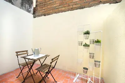 a table and chairs in a room with a wall at Hotelito Boutique Mercat in Hospitalet de Llobregat