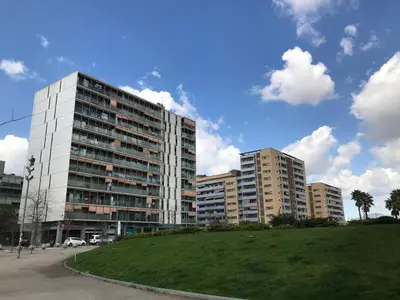 a large building in a city with a green field at Duplex in Santa María de Barbará