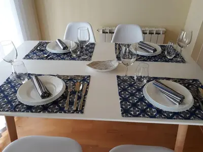 a white table with plates and wine glasses on it at Duplex in Santa María de Barbará