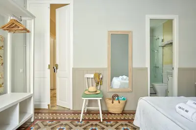 a bathroom with a bed and a chair in a room at Hostal Poblenou in Barcelona