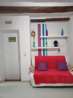 a red couch with two pillows in a room at Estudio con balcon Plaza España in Barcelona